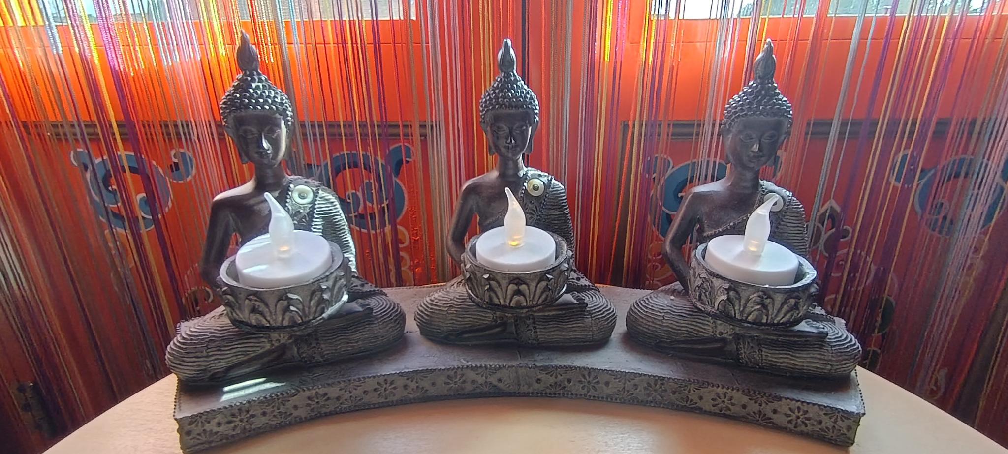 Photographie de trois statues de Bouddha.